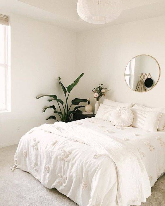 Dormitorio blanco decorado con plantas naturales