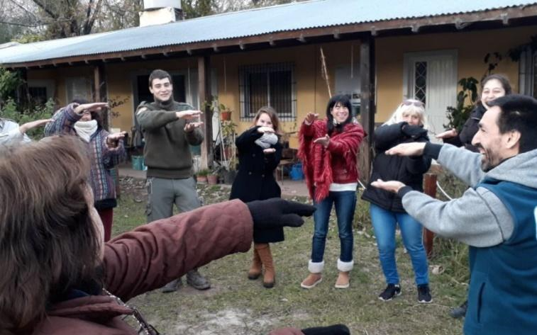 Un grupo de personas en frente de una casa Descripción generada automáticamente con confianza baja